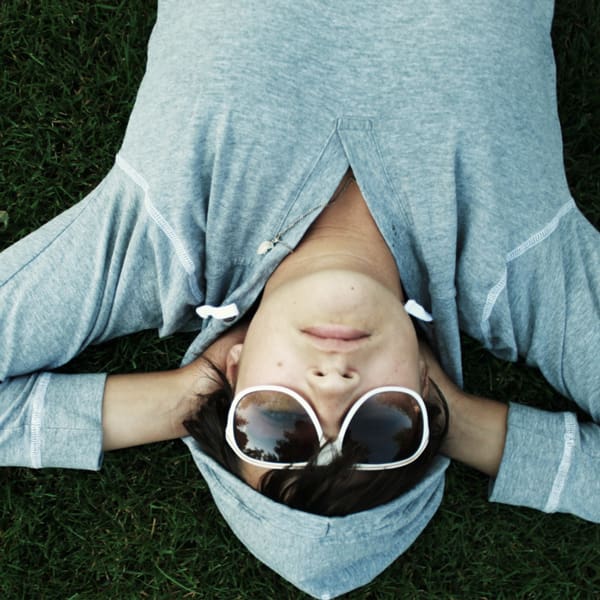 Poika makaa nurmikolla.